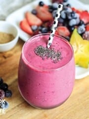 Camu camu smoothie on pink background surrounded by blackberries