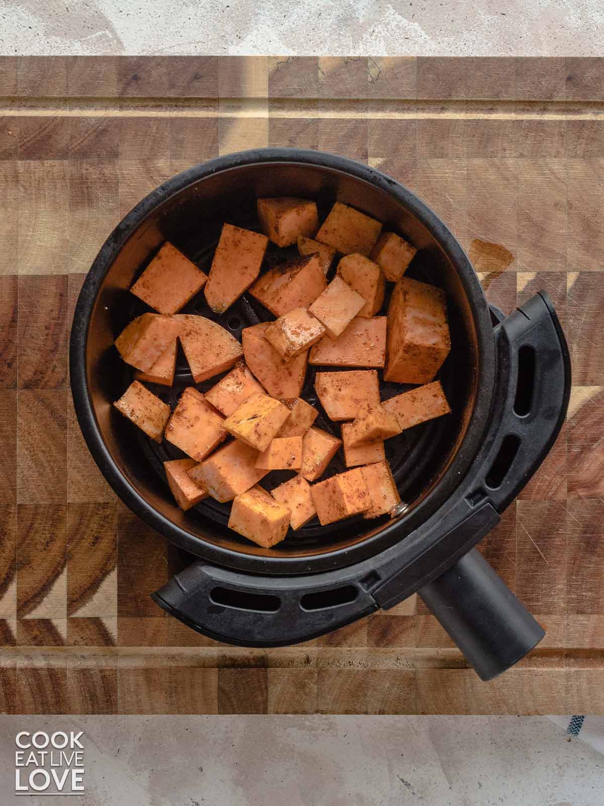 Sweet potatoes in the air fryer basket to cook.