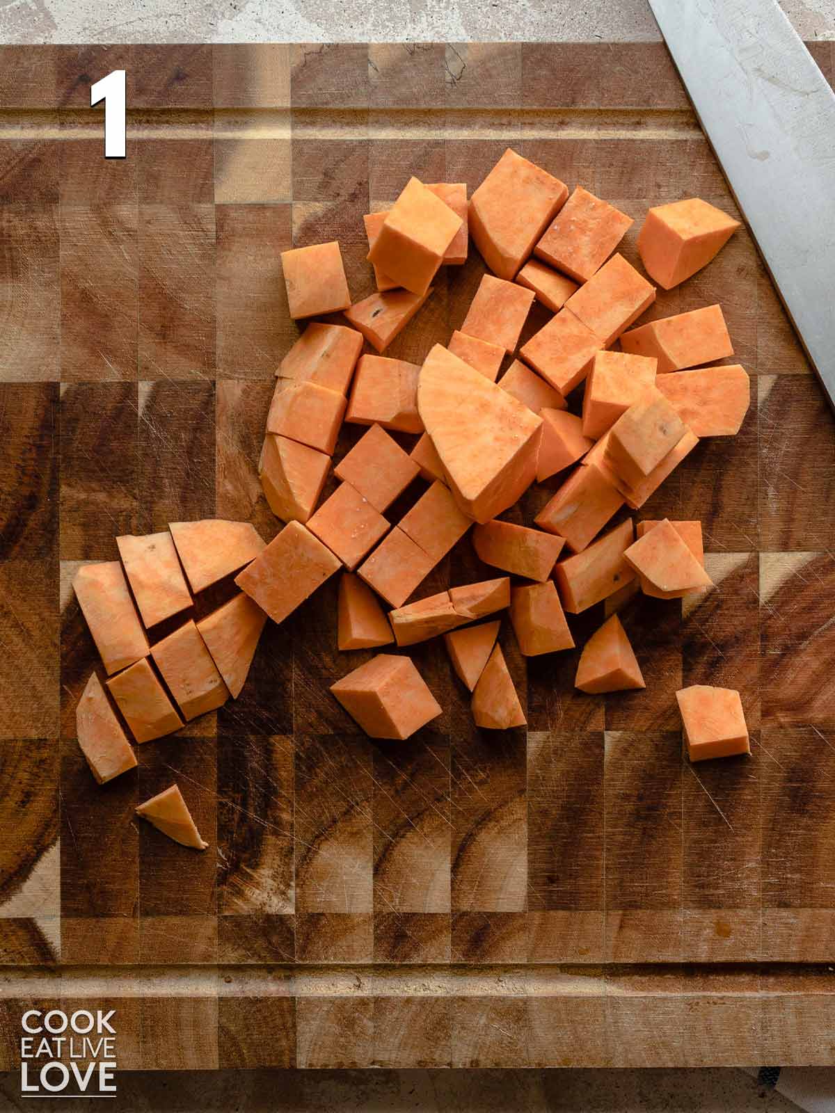Sweet potato cubes cut on a cutting board.
