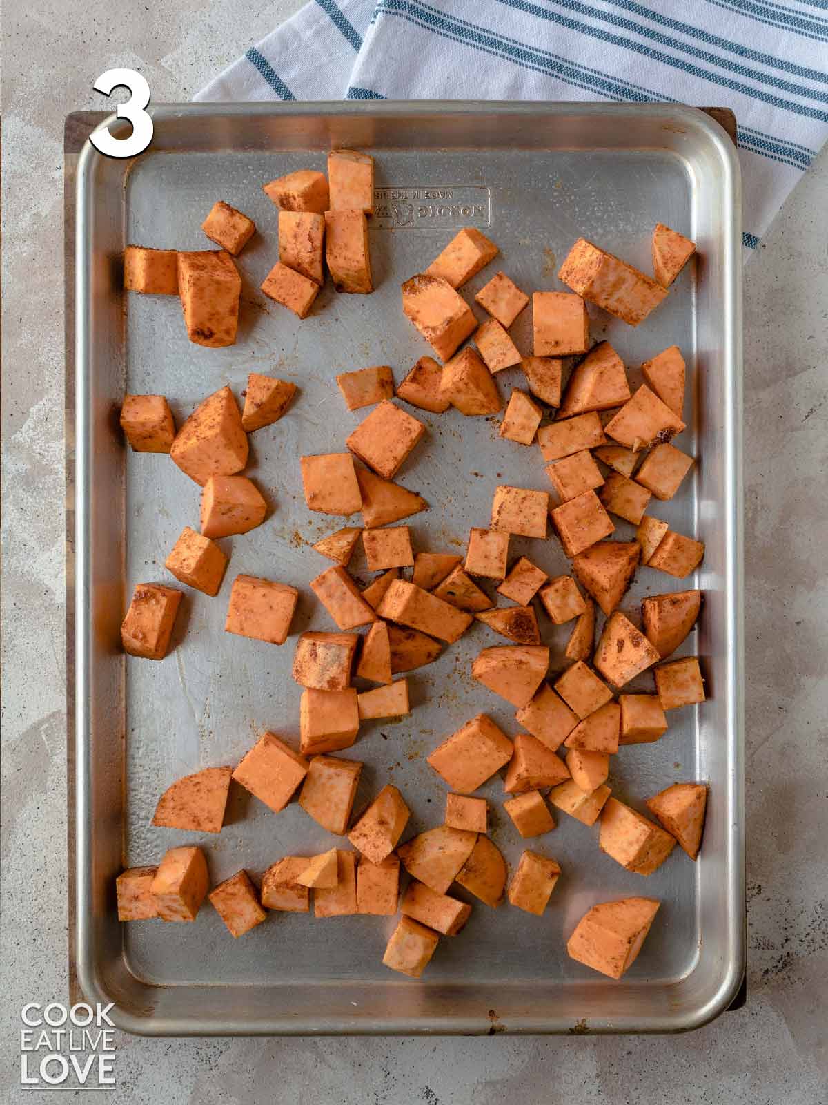 Sweet potatoes are spread out on a baking sheet.