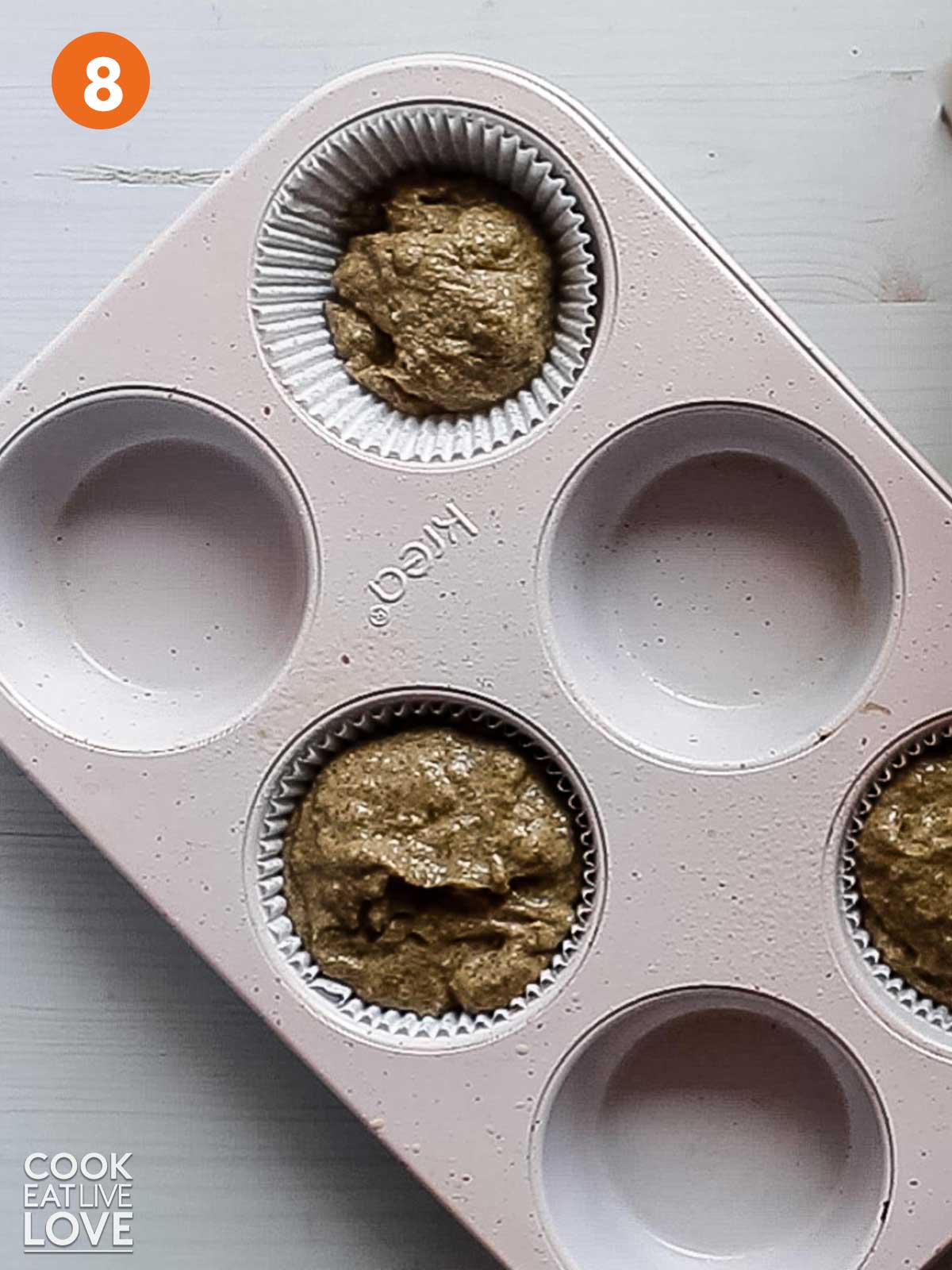 Filling up the muffin tin with muffin batter.