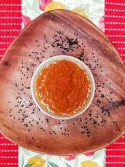 Finished dressing in bowl on wooden plate with black sesame seed garnish