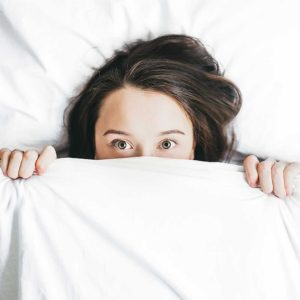 Woman wide awake lying in bed.