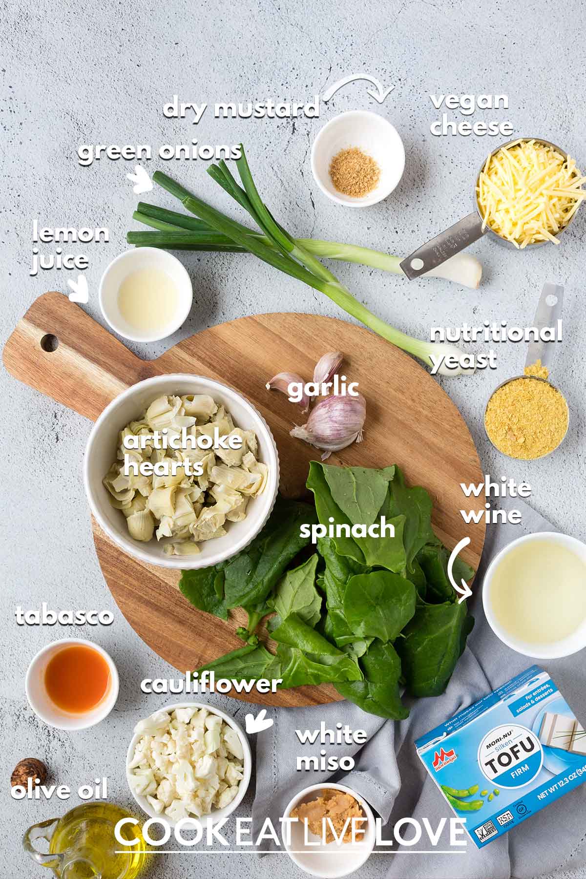 Ingredients to make dairy free spinach artichoke dip on the table with text labels.