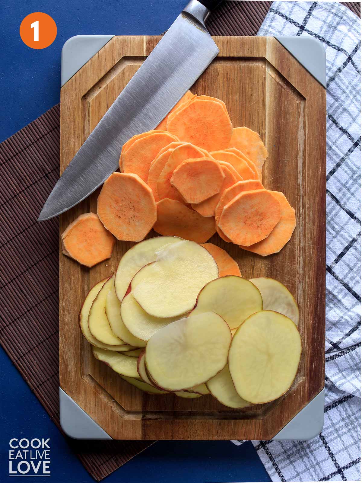 Sliced potatoes and sweet potatoes on a cutting board.