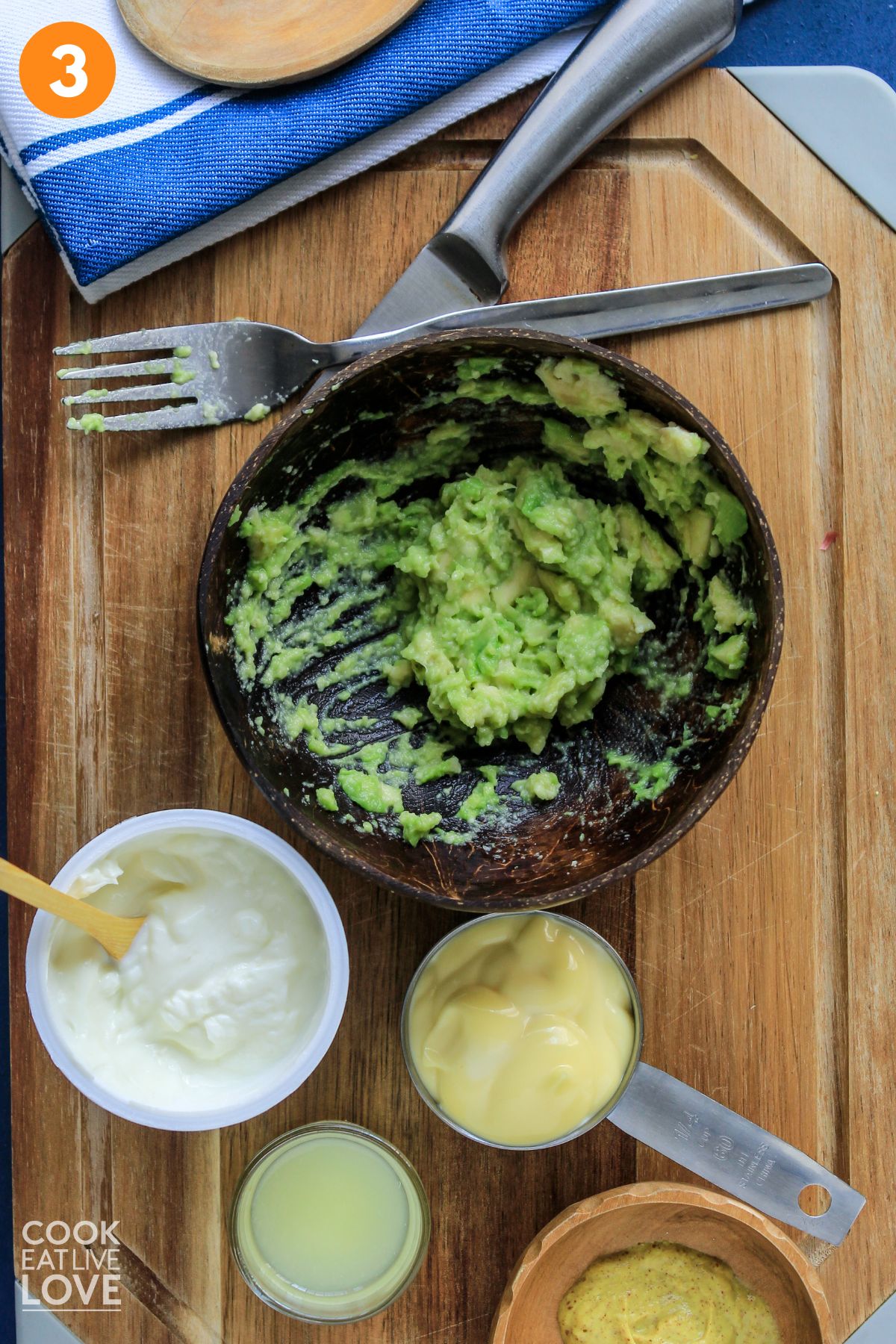 Mashing the avocado to make the smashed chickpea salad dressing. 