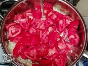 Tomatoes are added to pot.