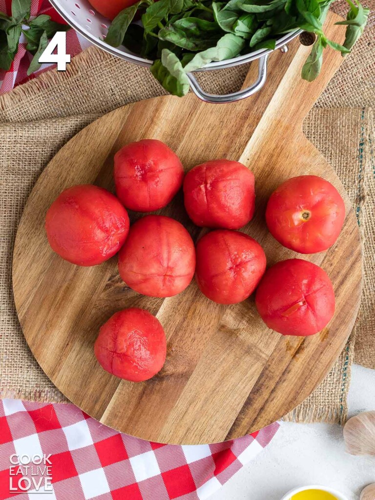 Peeled tomatoes on a cutting board.
