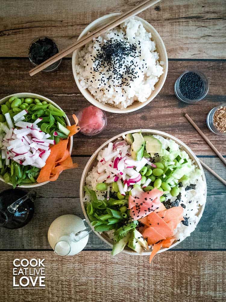 Overhead showing sushi rice bowl with healthy veggies on top.