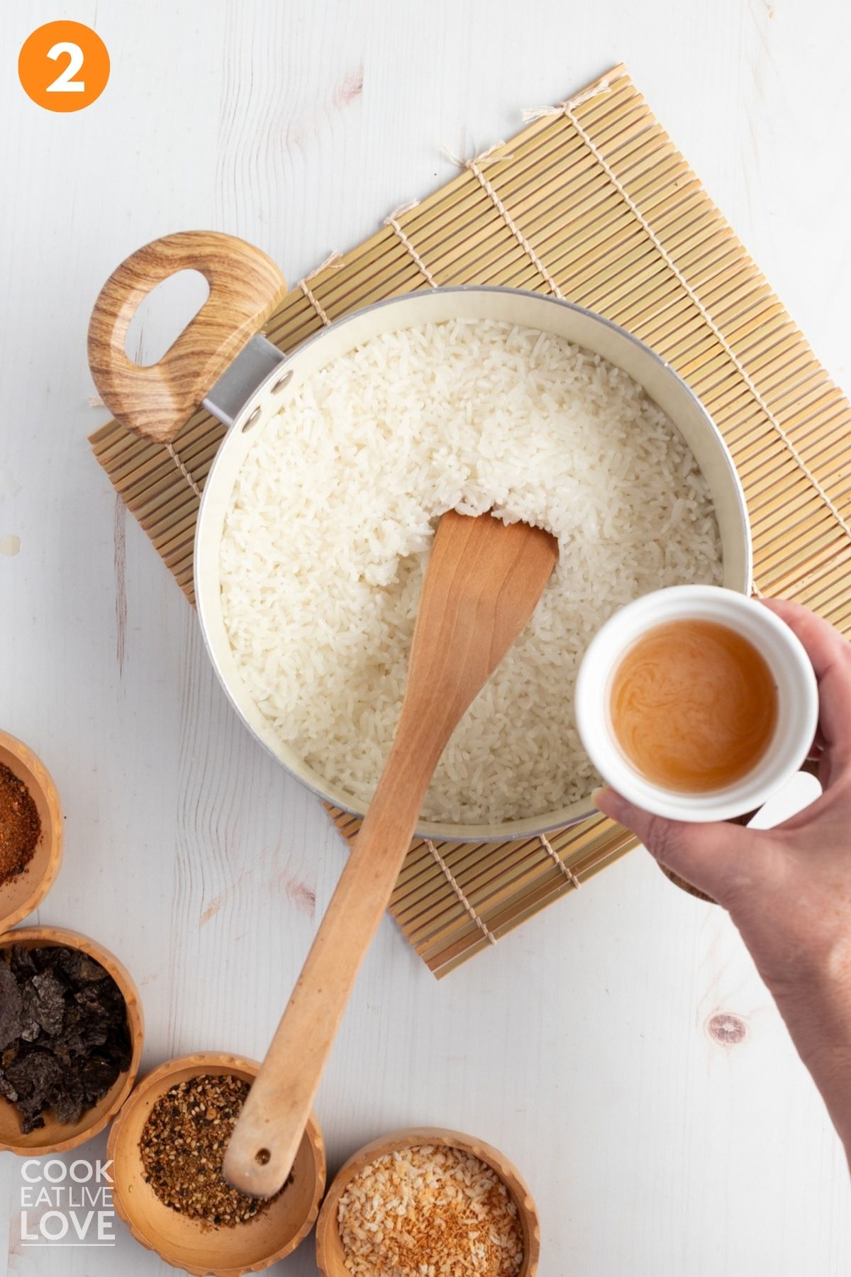 Adding the vinegar mixture to the rice. 
