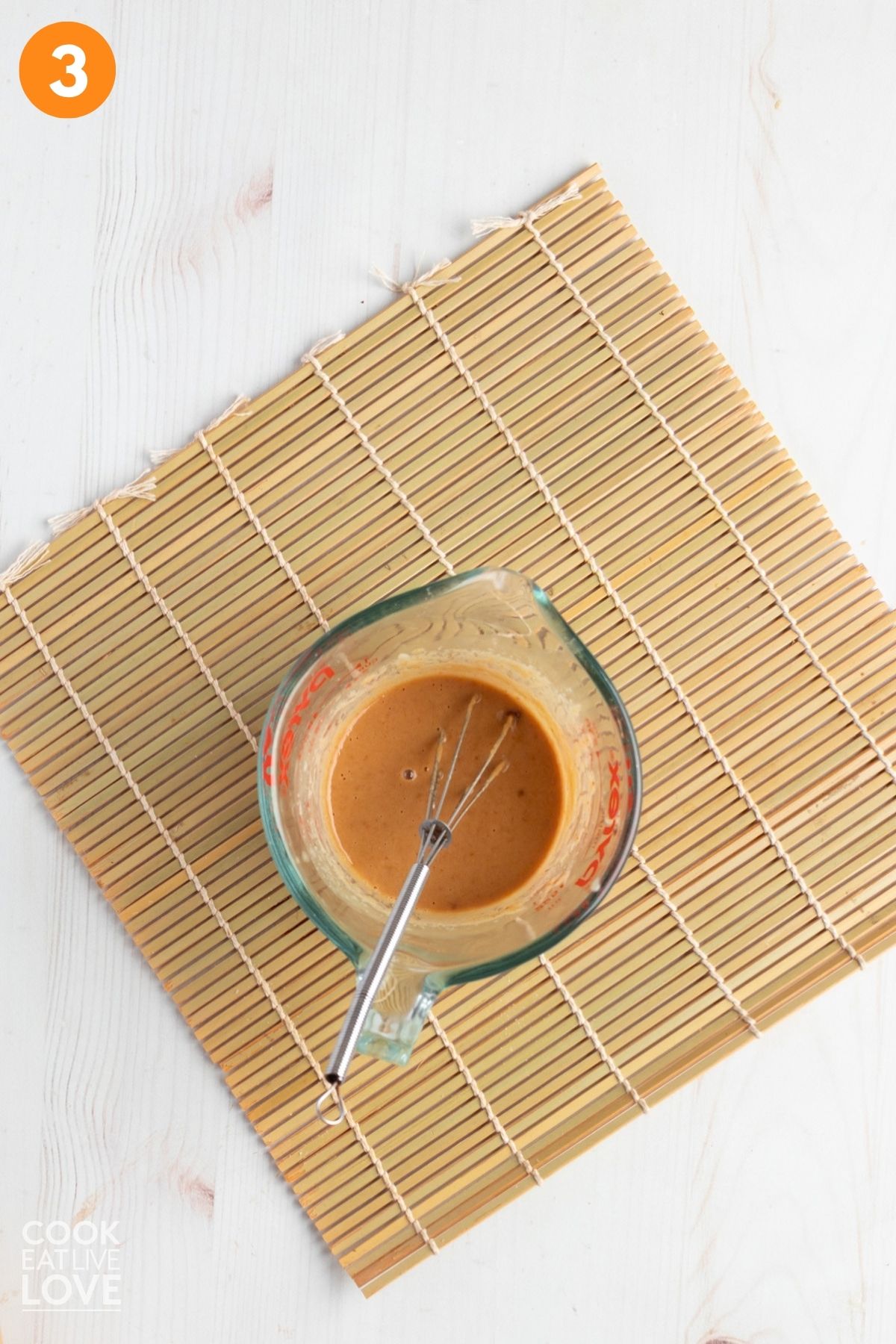 Tahini sauce whisked in a measuring cup. 
