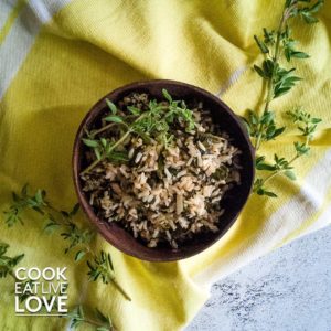 Coconut Bowl with Rice on white-gray concrete background with yellow linen and fresh oregano