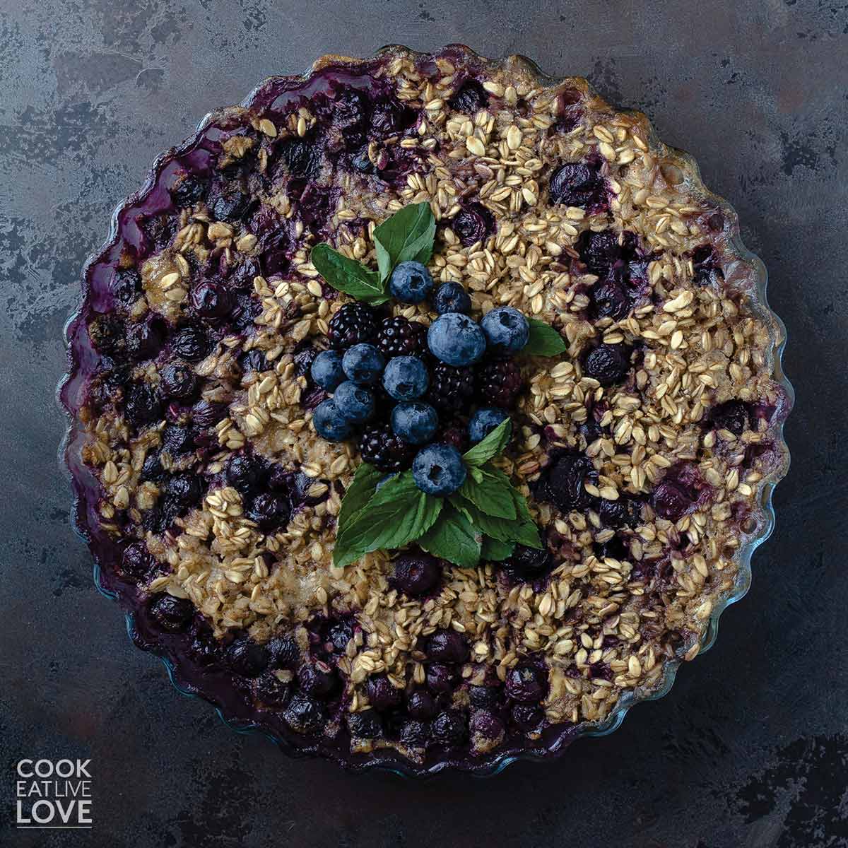 Overhead of pie plate with vegan baked oats on the table.