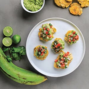 Baked tostones are topped with avocado and tomato salsa.