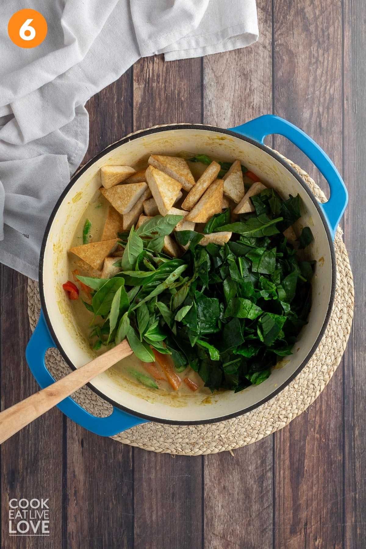 Spinach and tofu added to the pot of green curry.