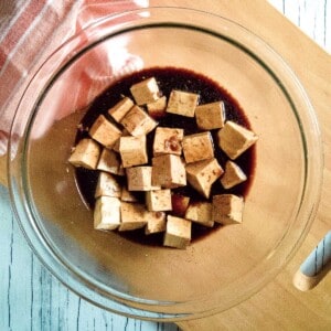Tofu and marinade in glass bowl