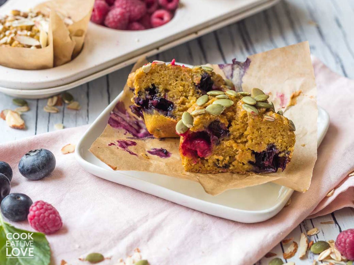 Pumpkin berry muffin on a plate with muffin pan behind with more