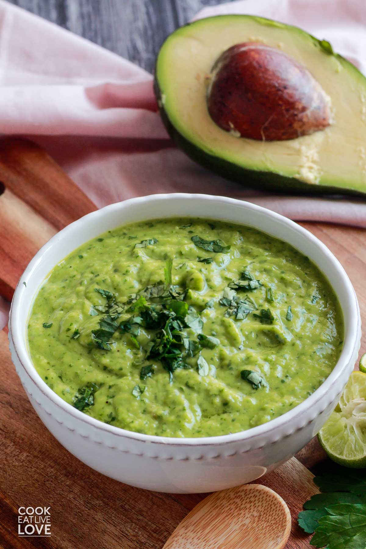 Bowl of green sauce on the table with a spoon.