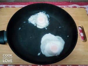 Eggs poaching in pan of water