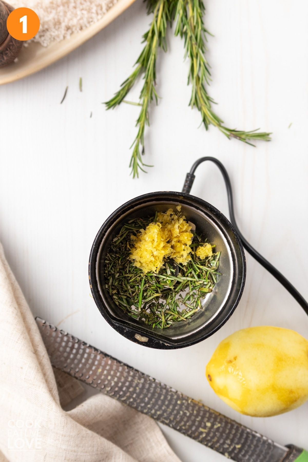 Rosemary and lemon zest placed in a chopper. 