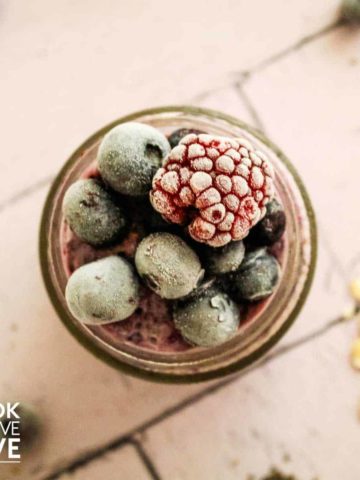 Frozen berries on top of oat jar on a table