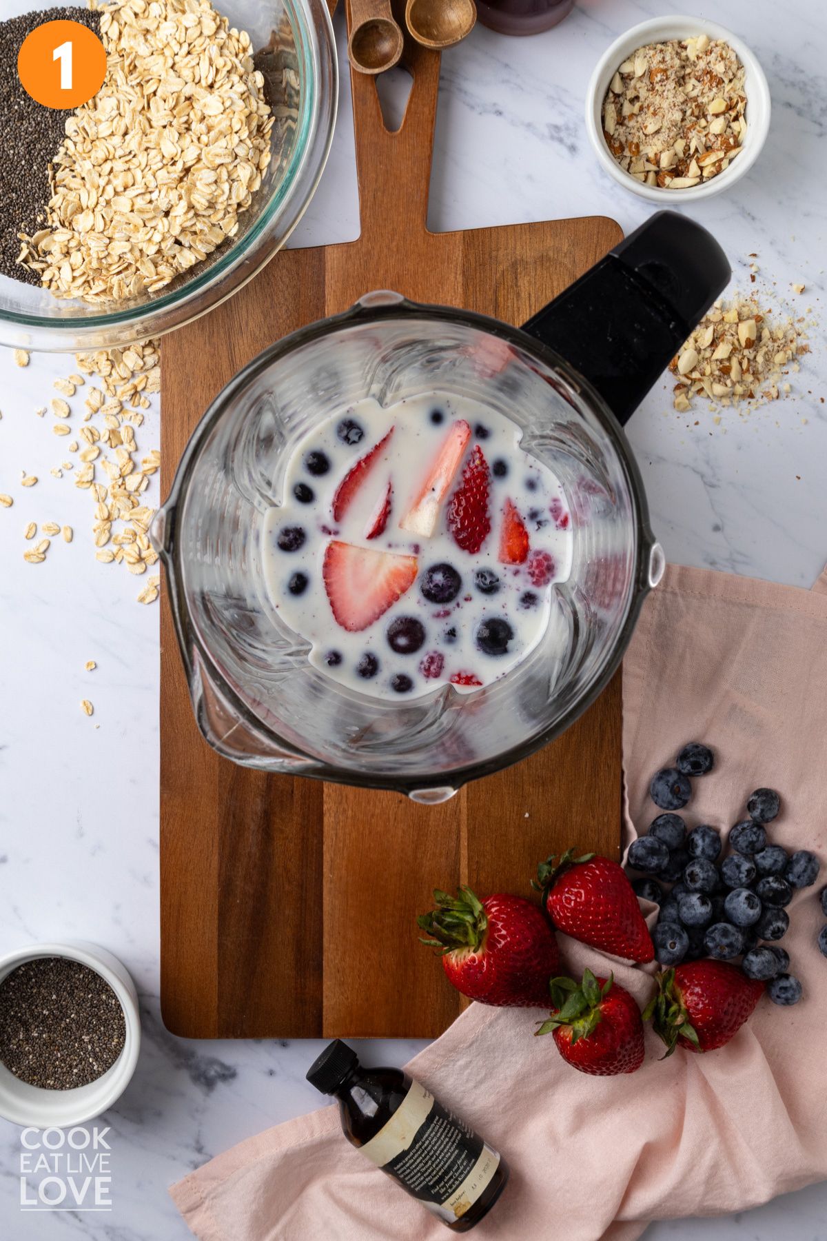 Milk and berries in a blender.