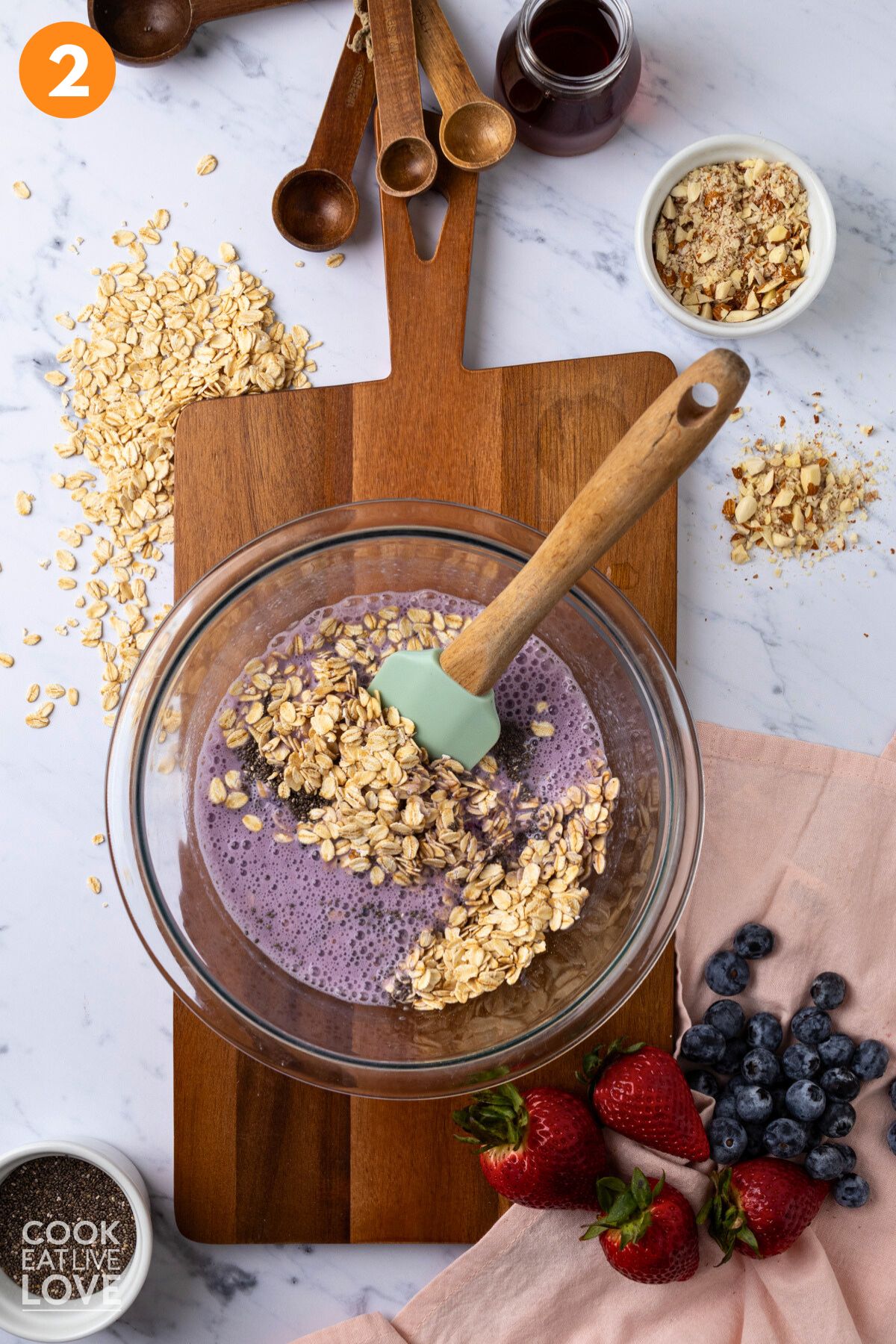 Blended berries and milk added to a bowl with oatmeal and chia.