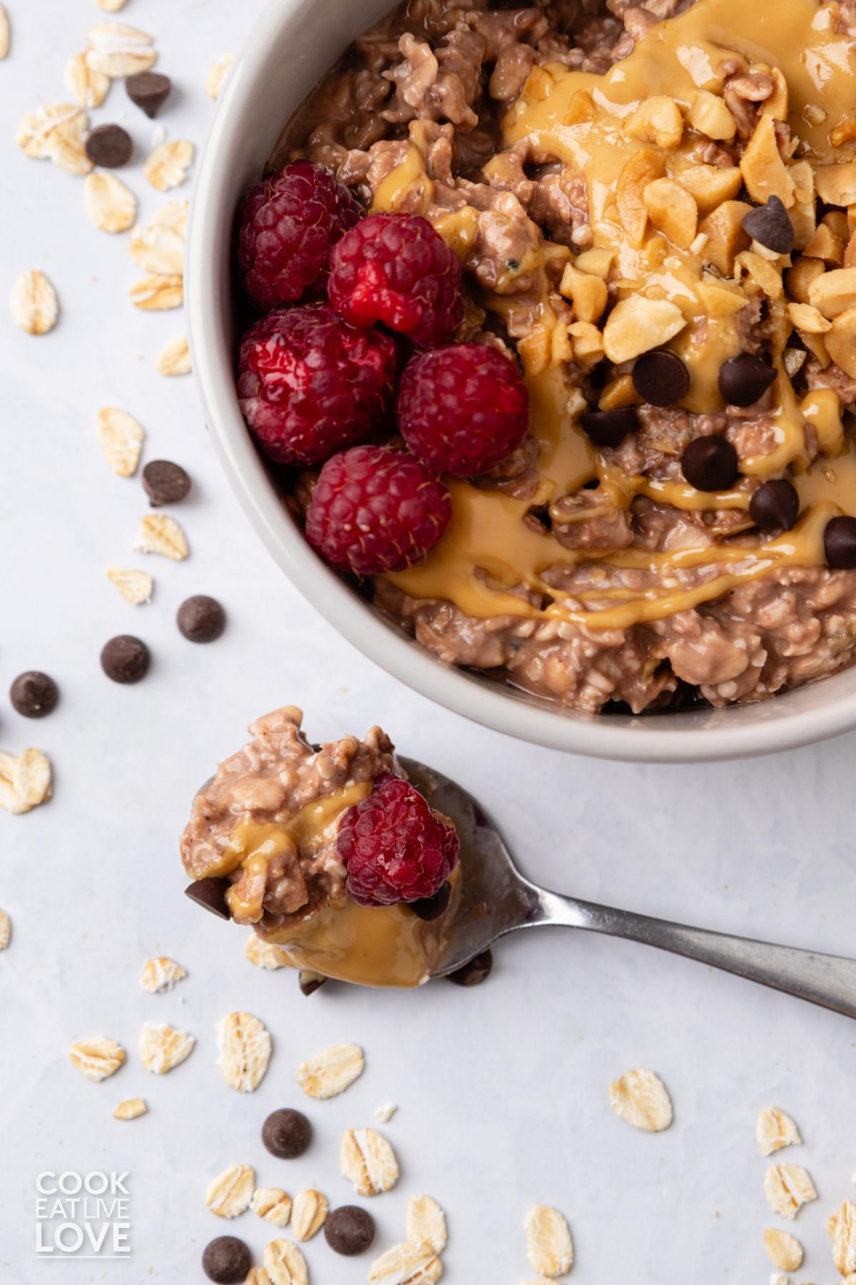 A spoonful of overnight peanut butter and jelly oats next to a bowl of more.