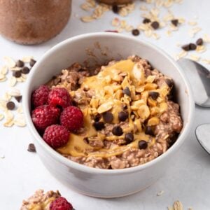 A bowl of peanut butter and jelly overnight oats on the table.