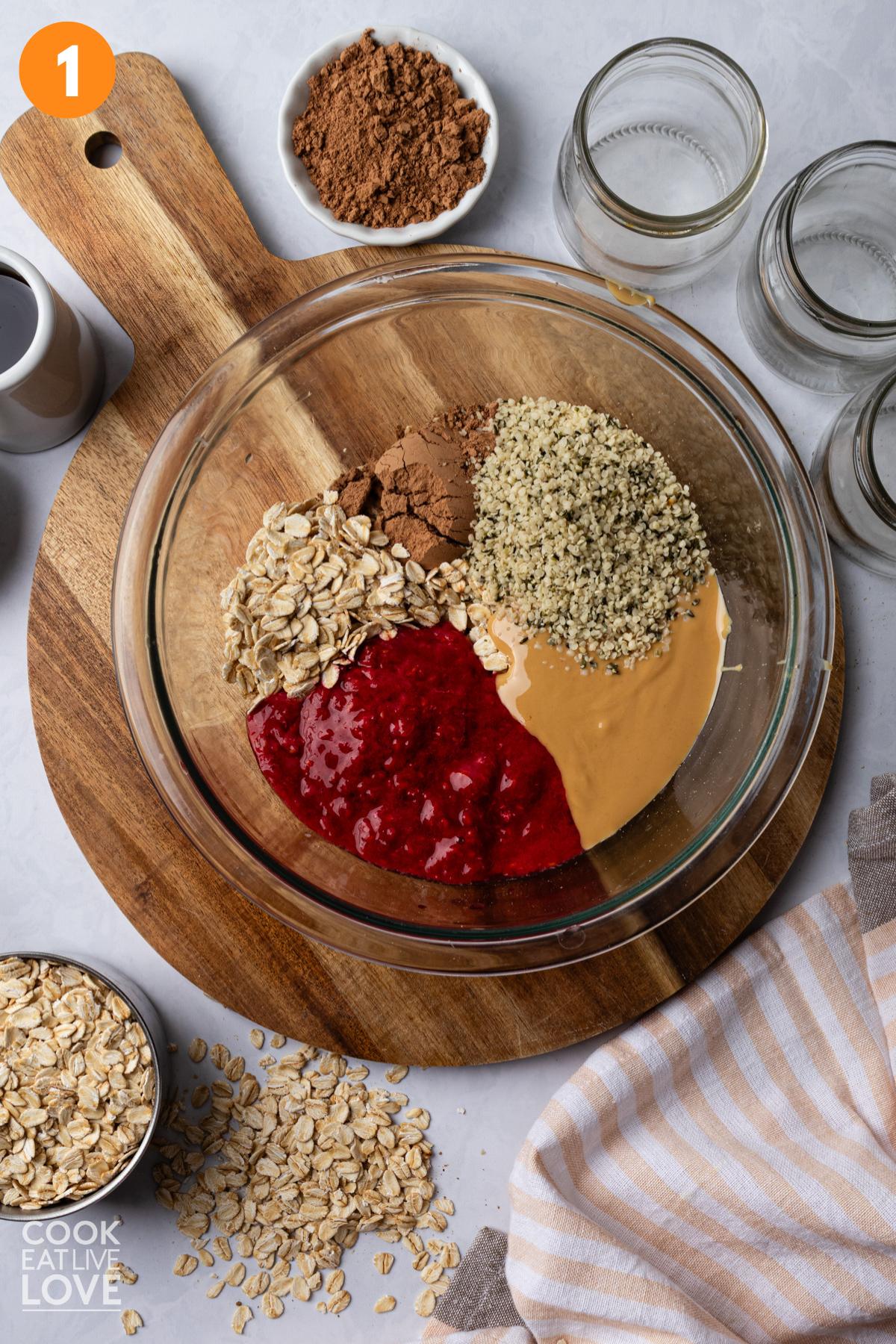 Ingredients to make pbj overnight oats in a bowl.