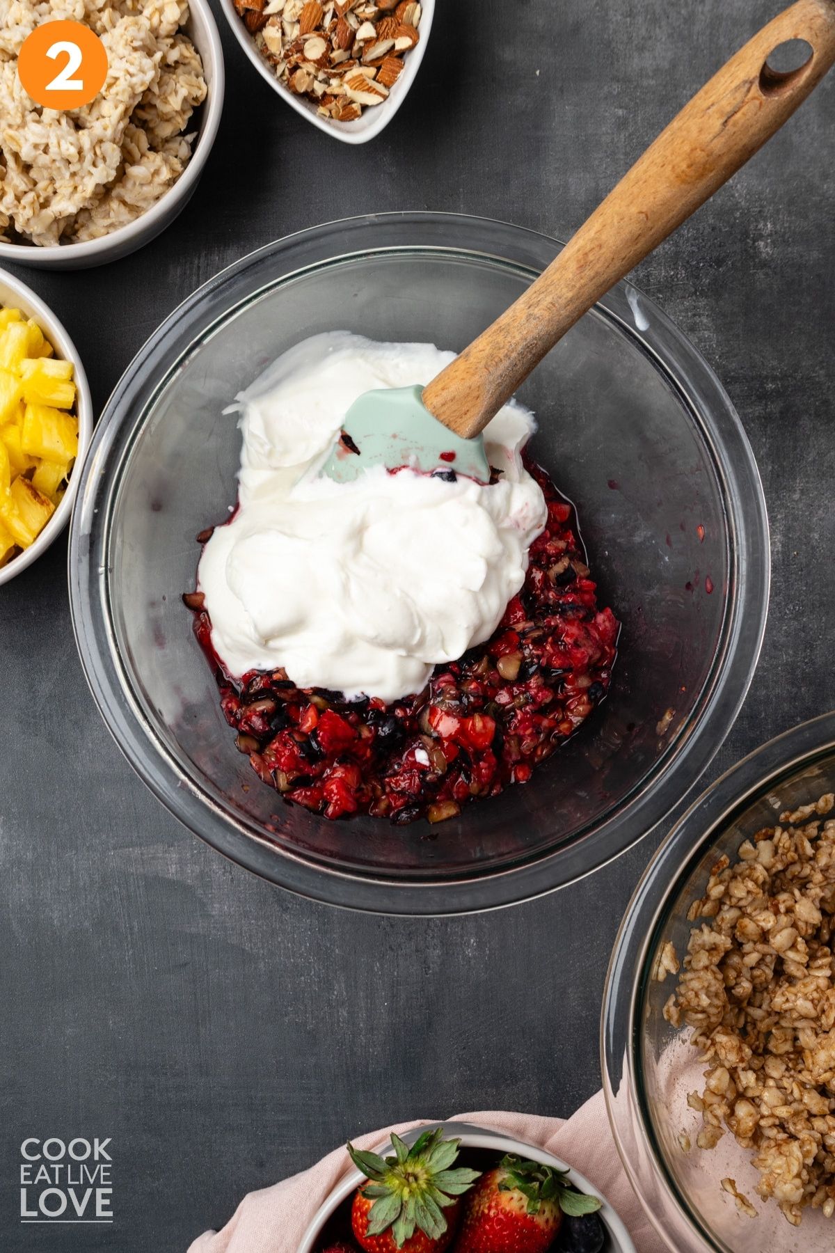Pureed fruit and yogurt in a bowl with a spatula.