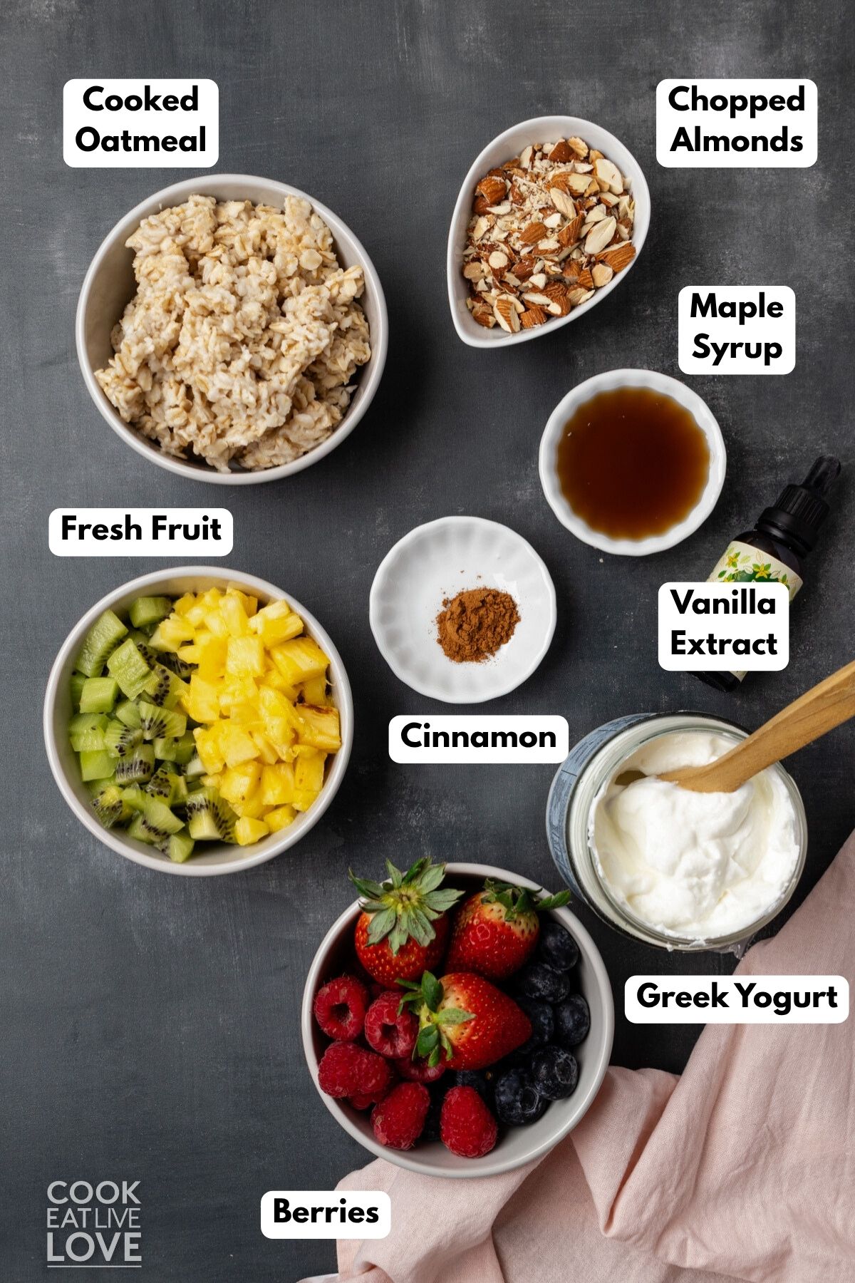 Ingredients to make breakfast parfaits with oatmeal and yogurt on a table.