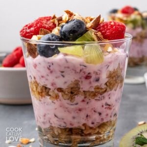 A breakfast parfait with layers of yogurt and oatmeal topped with fruit.