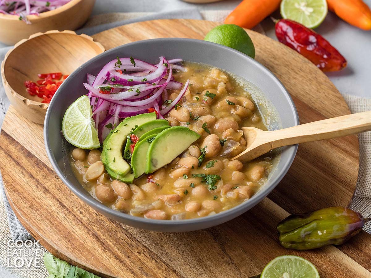 Peruvian style canary beans in a bowl with wooden spoon.