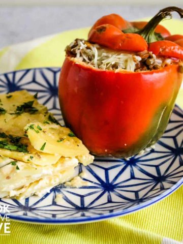 Plate on a table with stuffed pepper and layered potatoes