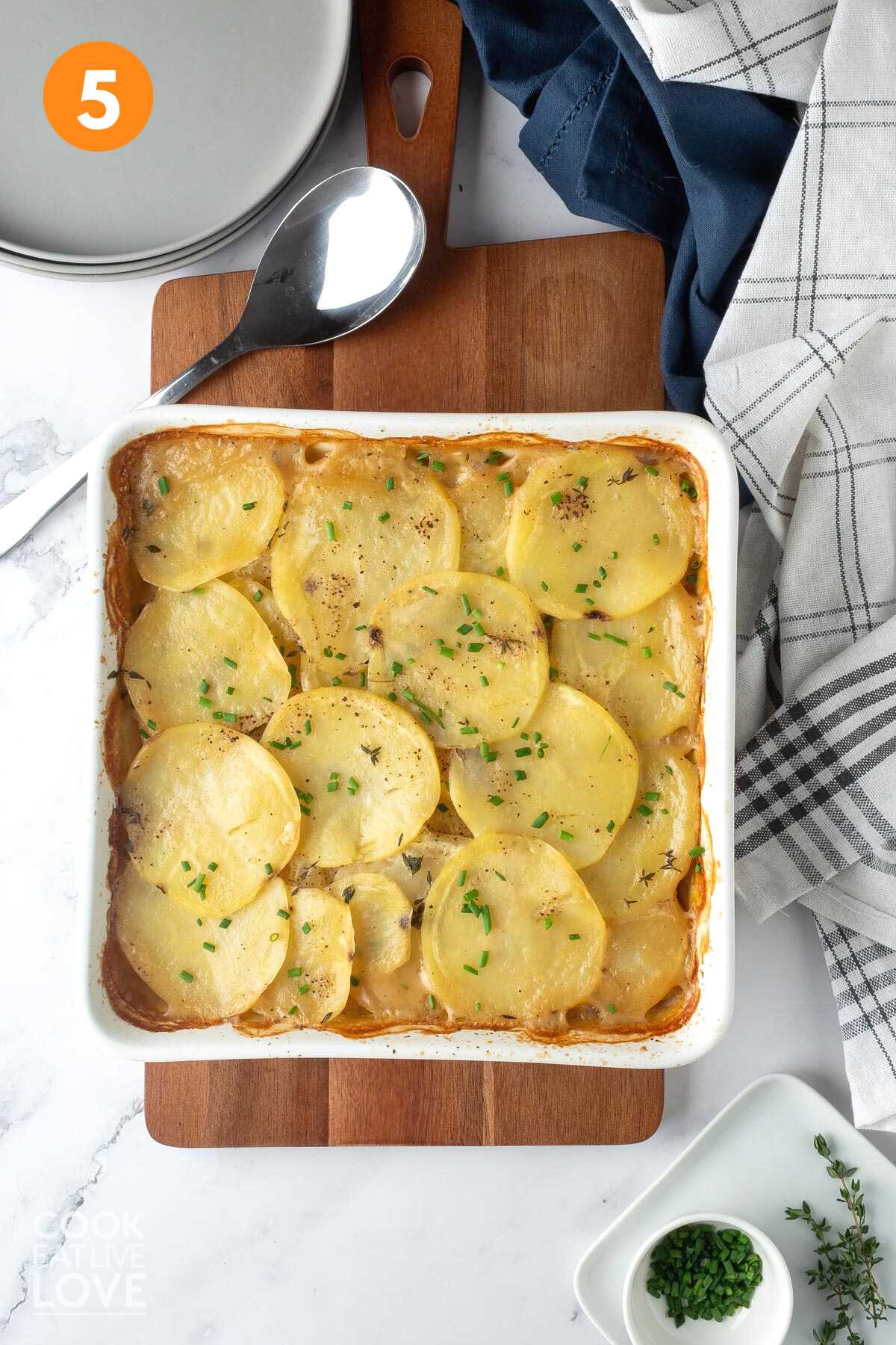 A dish of baked vegan scalloped potatoes on the table.