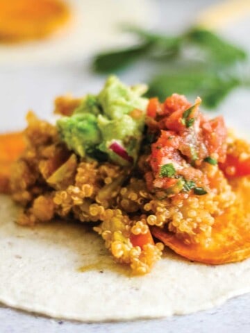 Corn tortilla on a table with sweet potatoes and quinoa