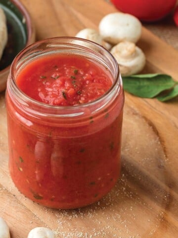 Jar of fresh tomato pizza sauce on the counter.