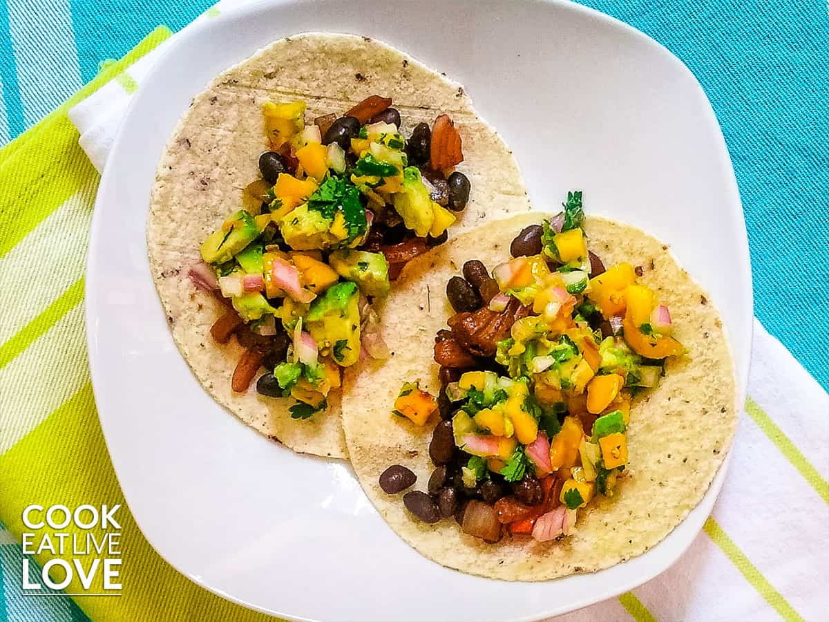 Black bean and mango tacos on white plate.