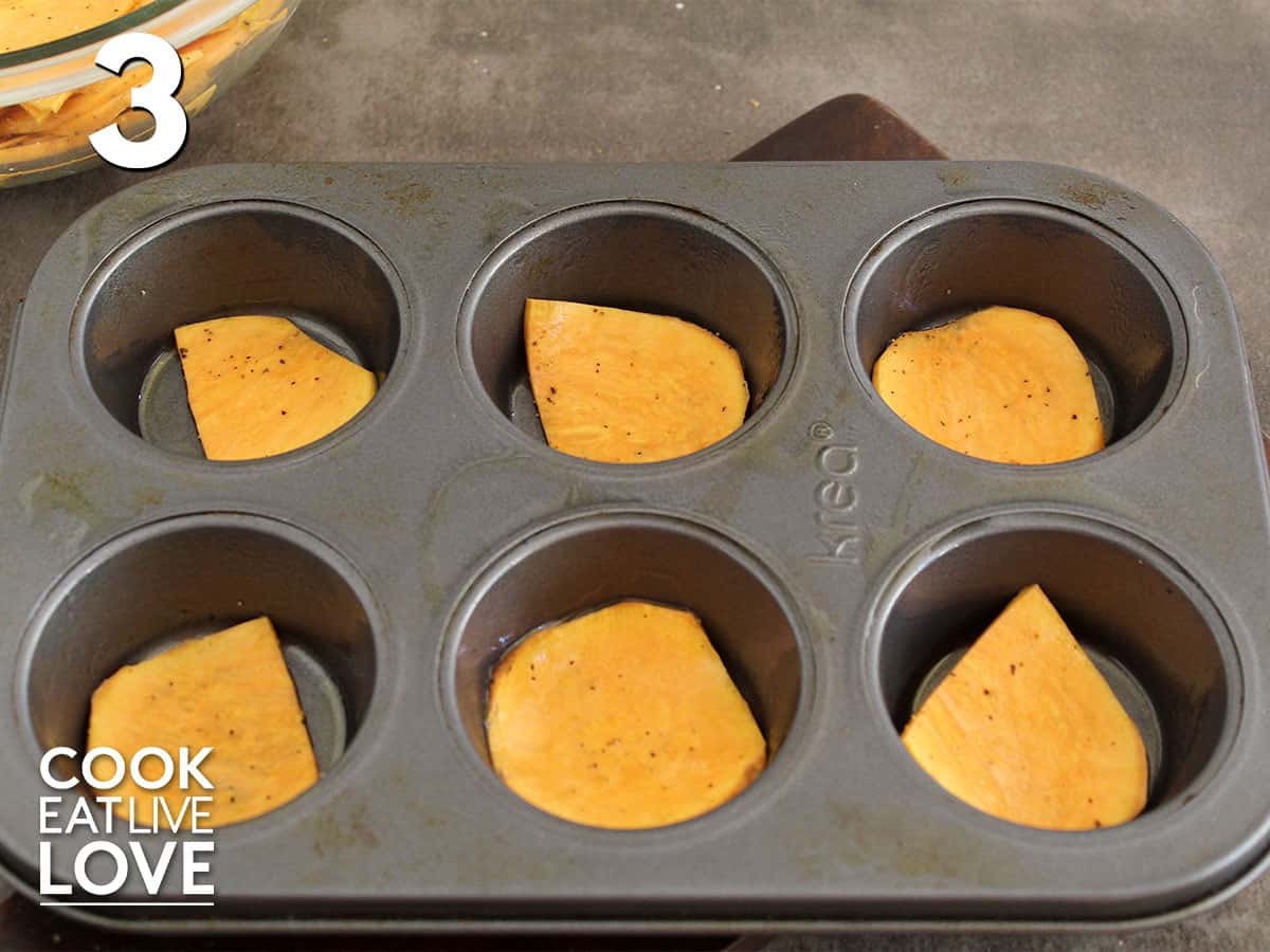Muffin tin with slice of sweet potato in bottom of each cutout