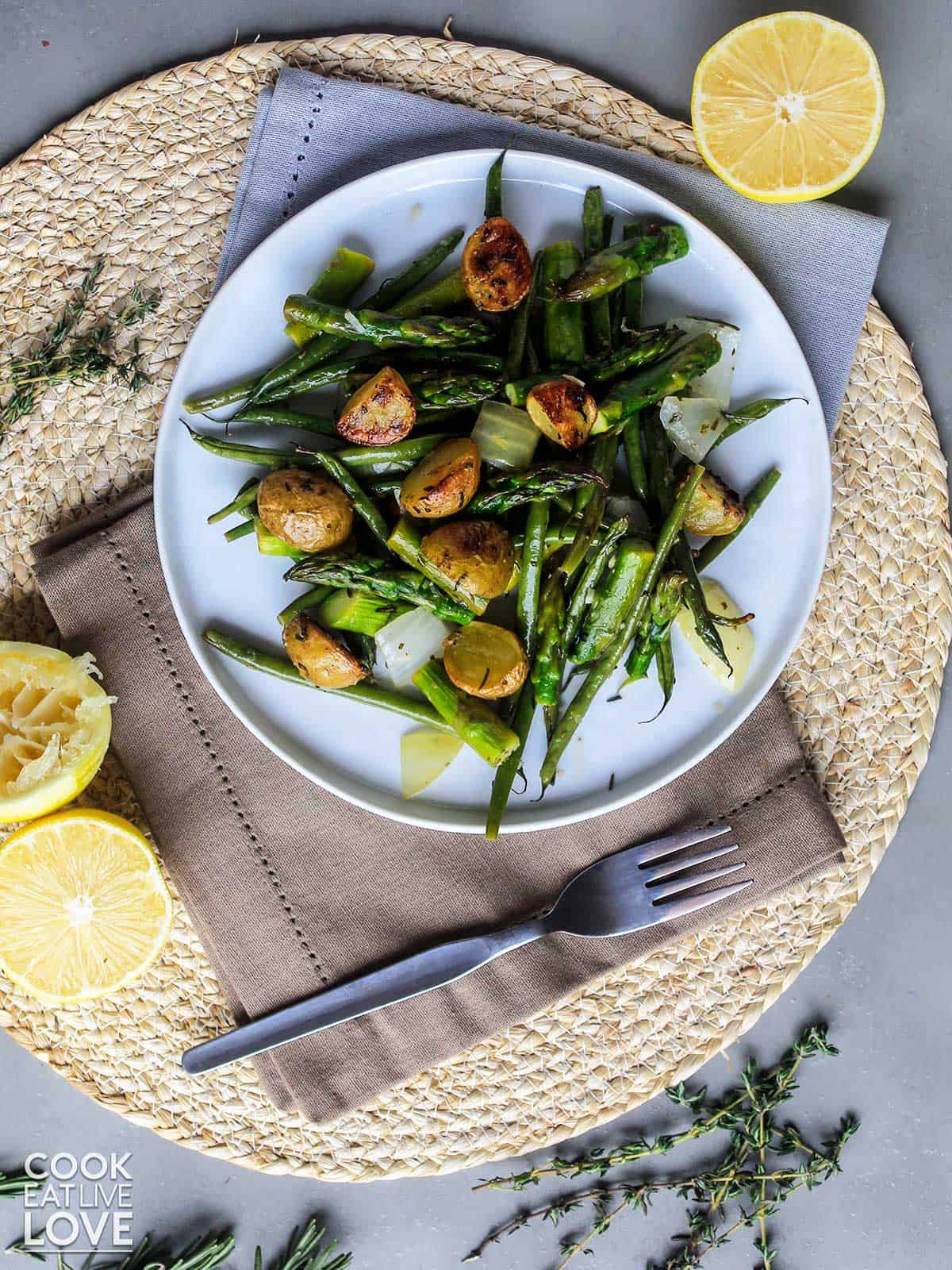 Veggie potato bake served up on a plate with fork and lemons.