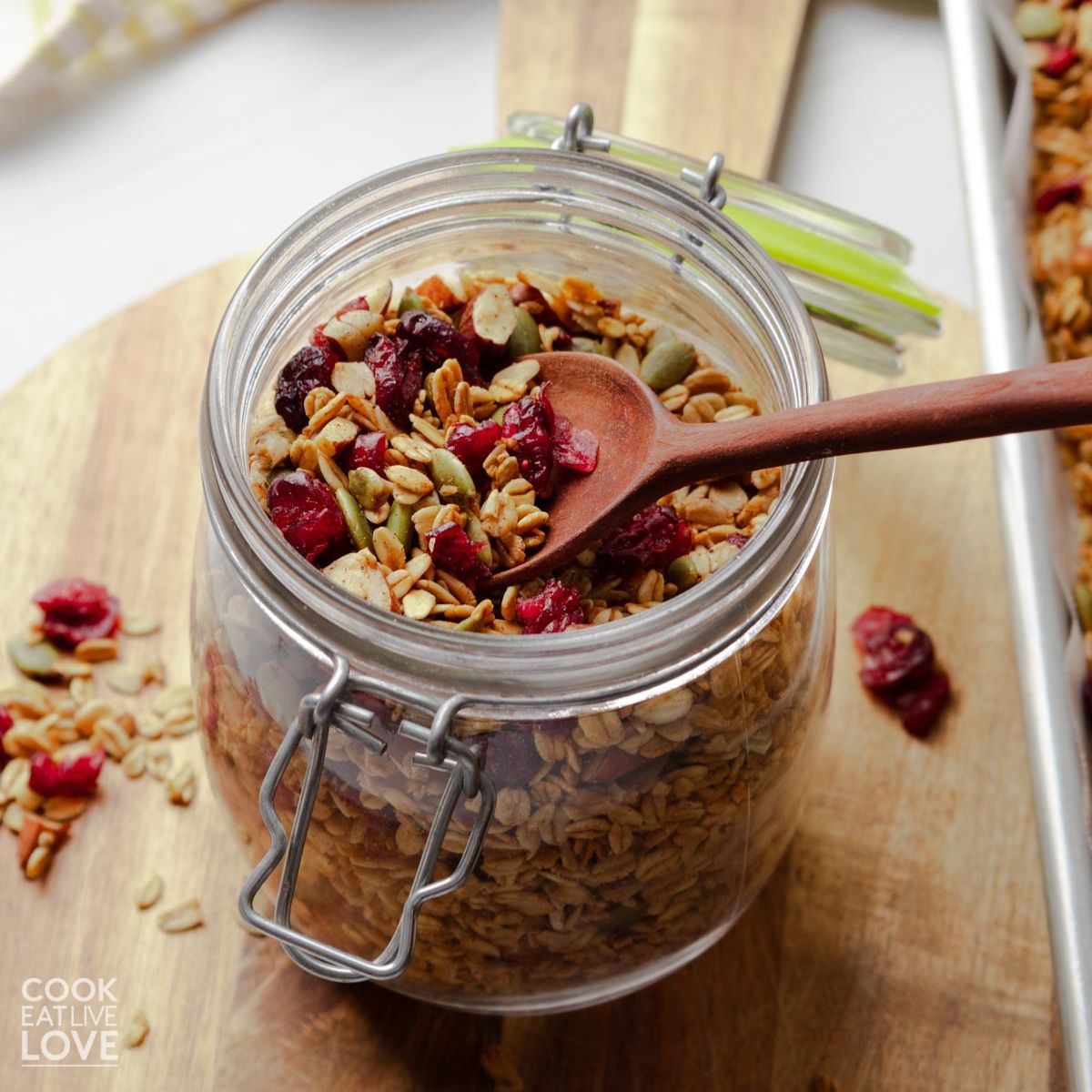 A jar of pumpkin spice granola with a spoon in the jar.