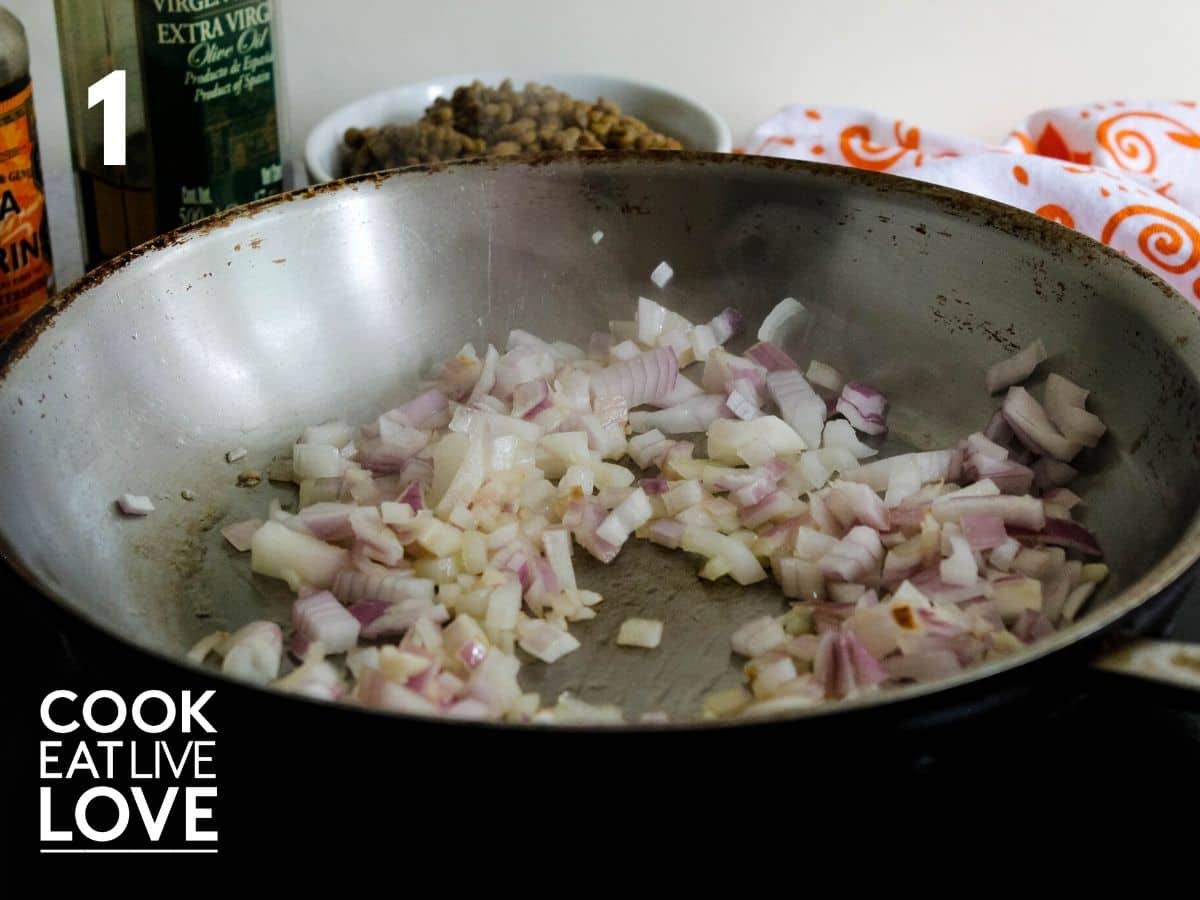 Onions and garlic and shown cooking in pan.