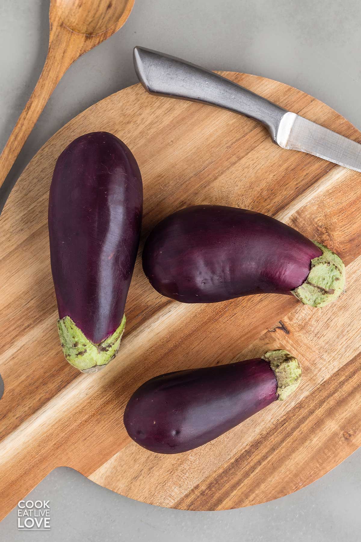 Whole eggplant on the table on a board.