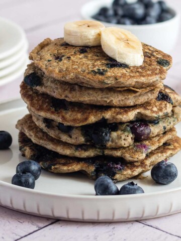 Stack of vegan chia pancakes on white and gray spotted plate.