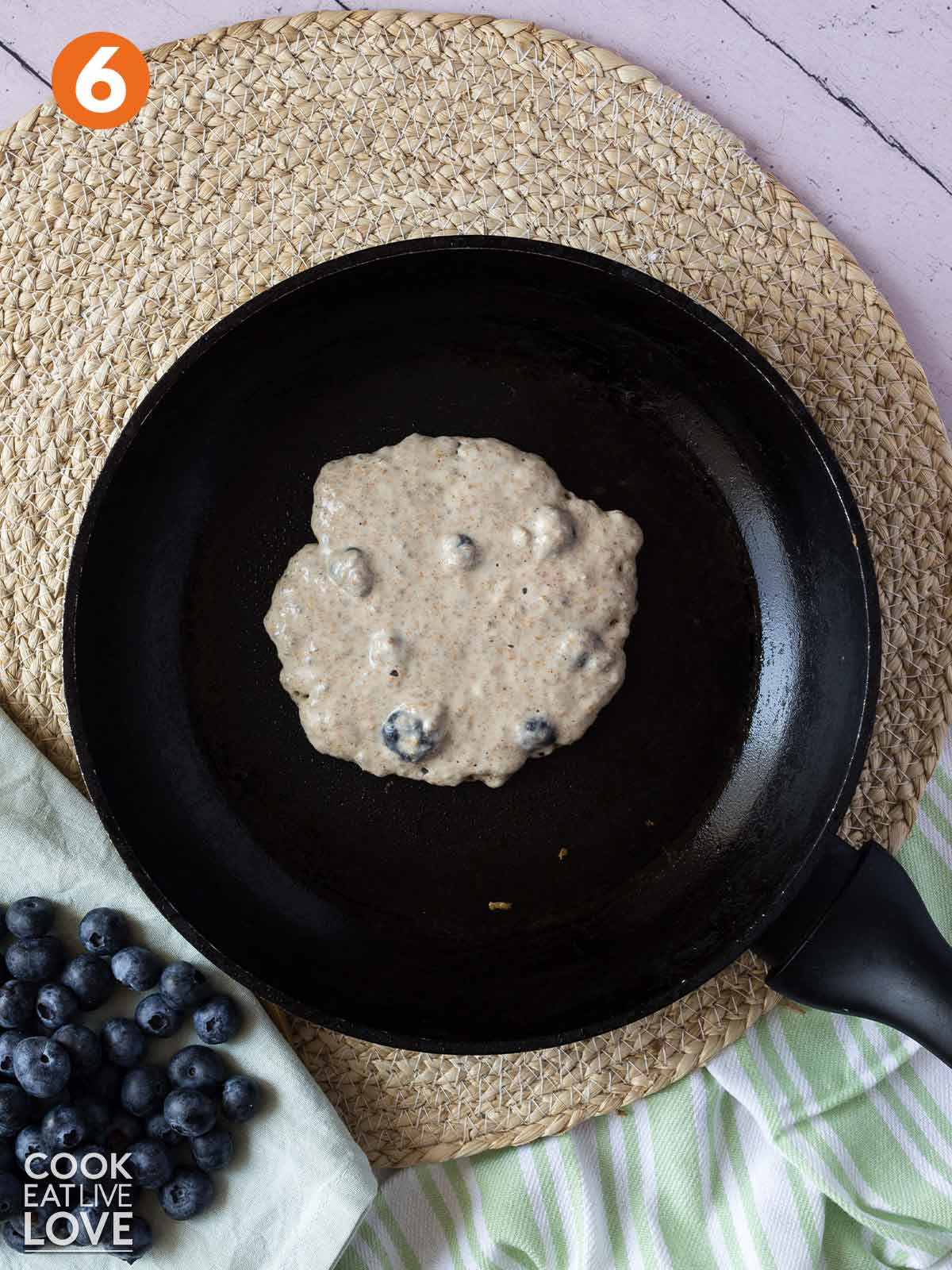 Vegan blueberry chia pancake cooking in a pan.