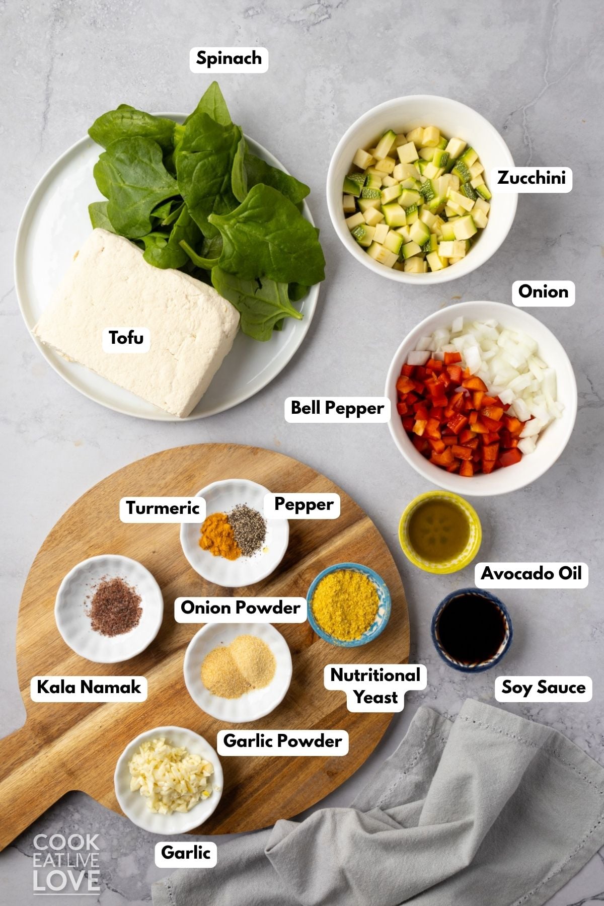 Ingredients to make tofu scramble on a table with text labels. 