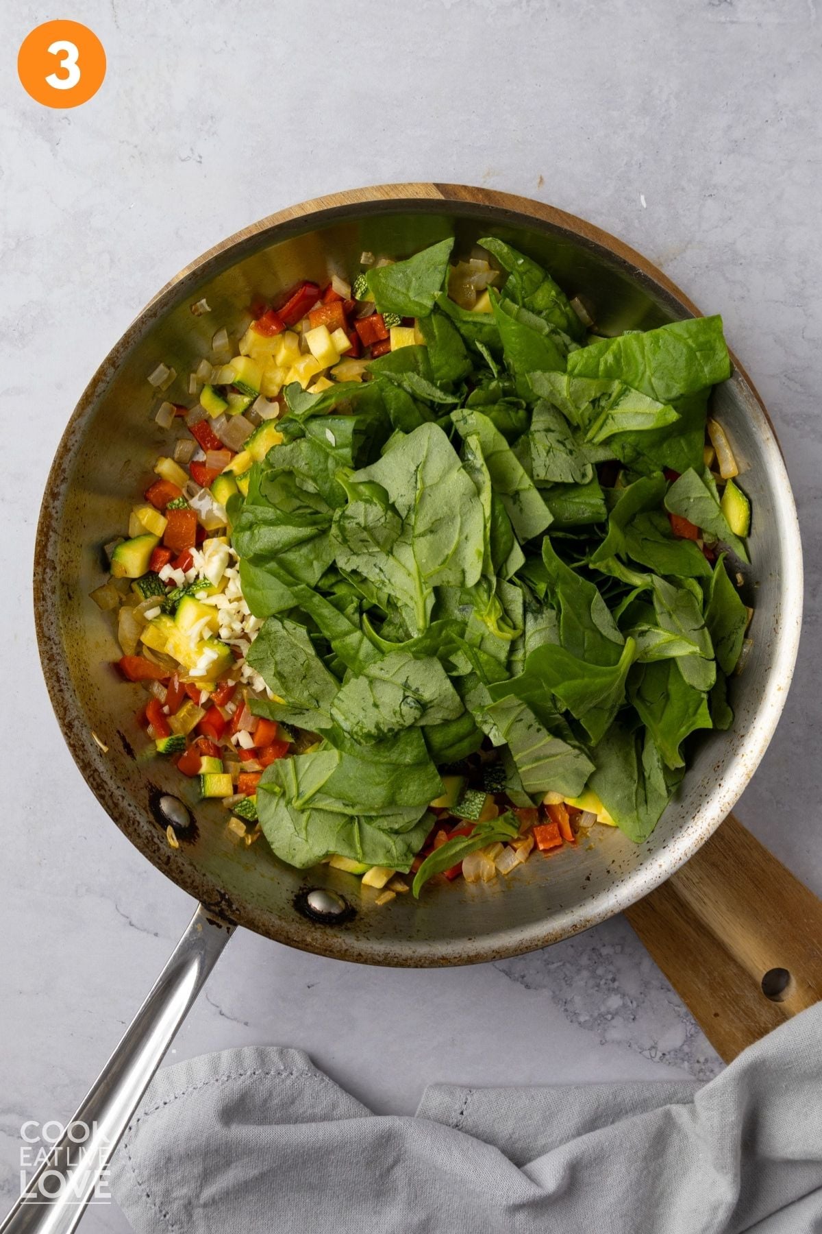 Spinach added to the skillet. 