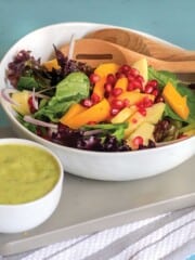 Mango avocado salad in a bowl with dressing on the side