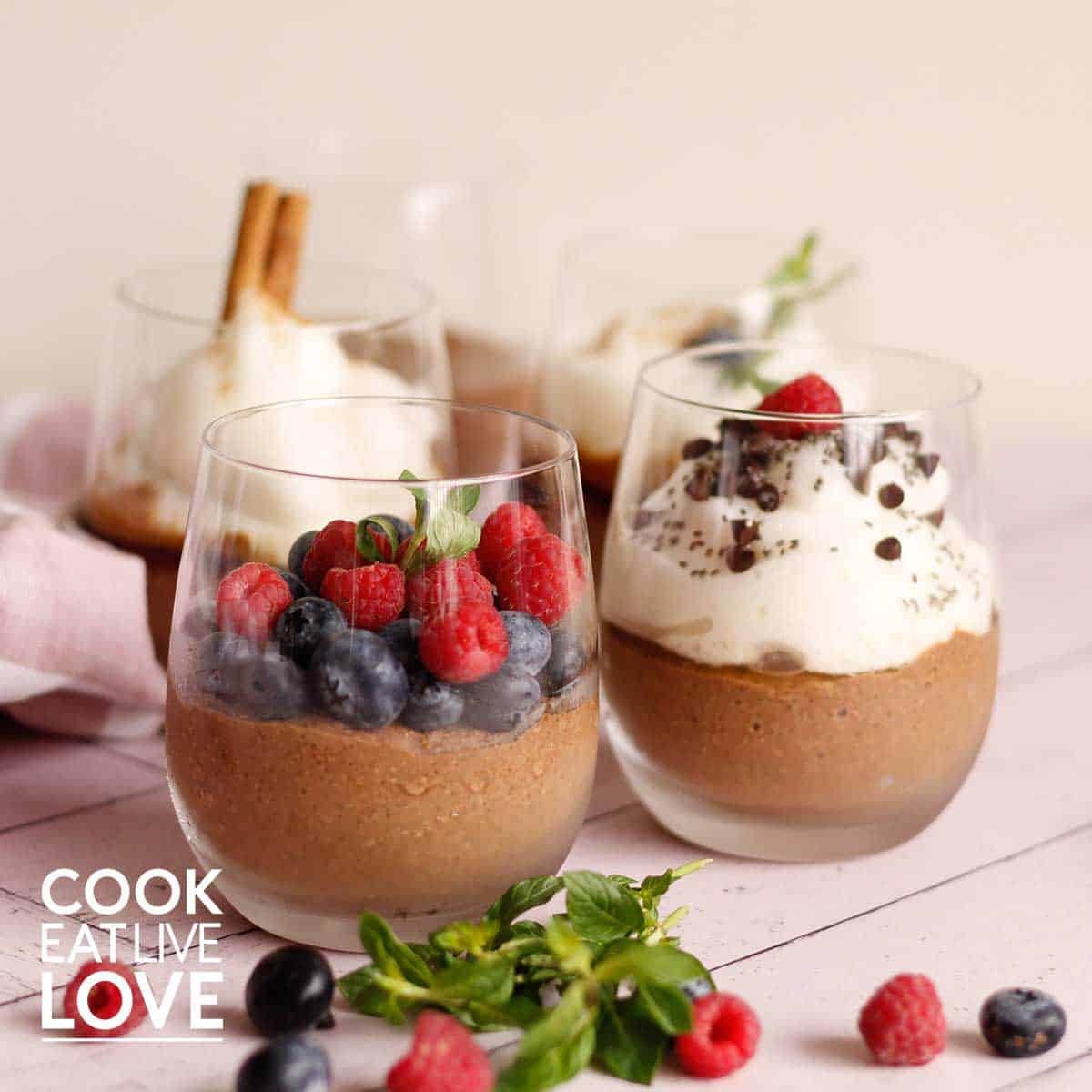 Glasses of chocolate chia pudding on pink table.